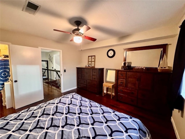 bedroom featuring ceiling fan, wood finished floors, visible vents, and baseboards