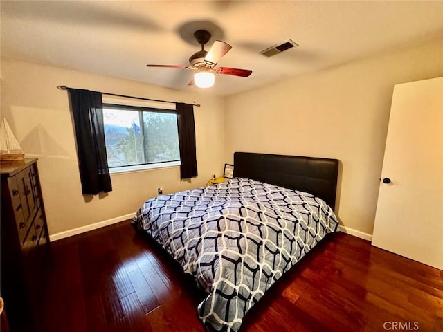 bedroom with a ceiling fan, baseboards, visible vents, and wood finished floors