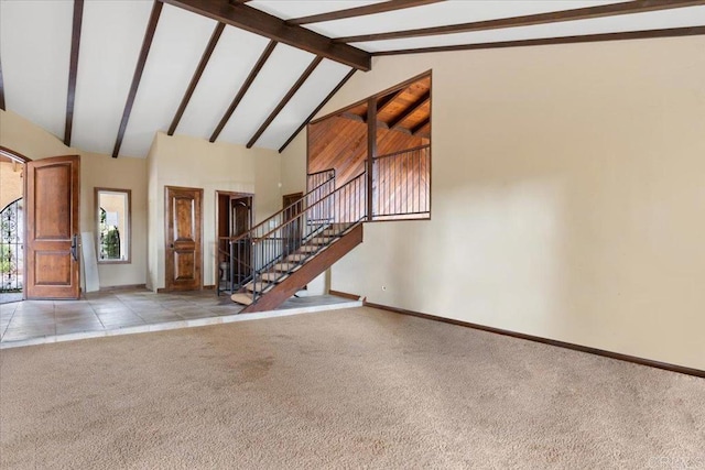 interior space featuring lofted ceiling with beams, tile patterned flooring, stairs, and baseboards