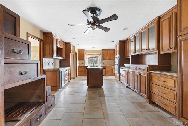 kitchen featuring open shelves, a kitchen island, brown cabinetry, and a ceiling fan