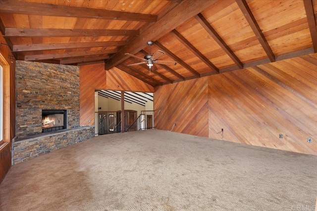 unfurnished living room with vaulted ceiling with beams, wooden ceiling, wooden walls, a fireplace, and carpet