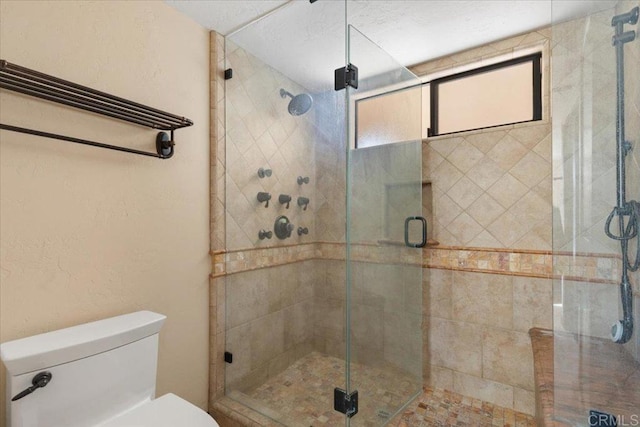 full bathroom featuring a stall shower and toilet