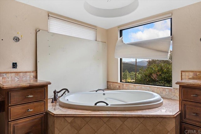 bathroom featuring a garden tub, a mountain view, and vanity