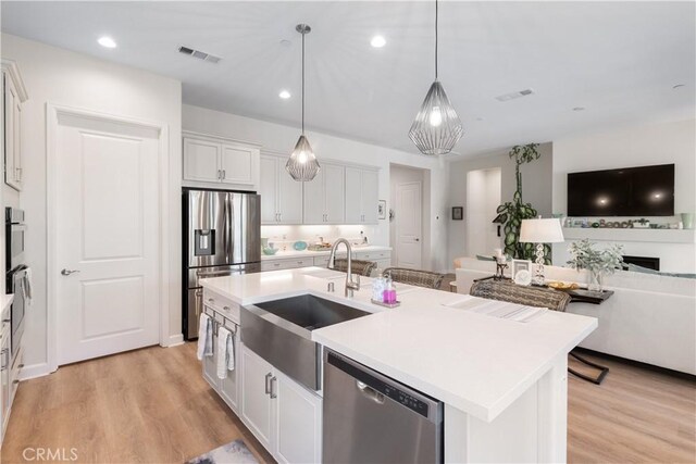 24674 Crestley Dr, Corona, CA 92883 - kitchen featuring stainless steel appliances, a sink, open floor plan, white cabinetry, and light countertops