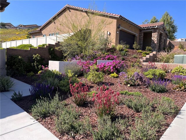 24674 Crestley Dr, Corona, CA 92883 - view of home's exterior featuring stone siding, stucco siding, a garage, and a tiled roof