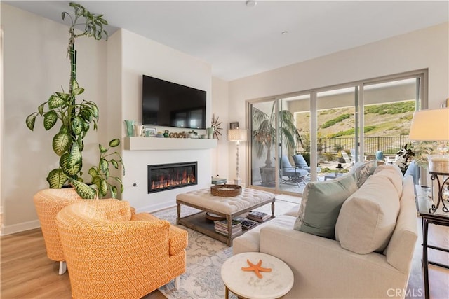 24674 Crestley Dr, Corona, CA 92883 - living area featuring a glass covered fireplace, wood finished floors, and baseboards
