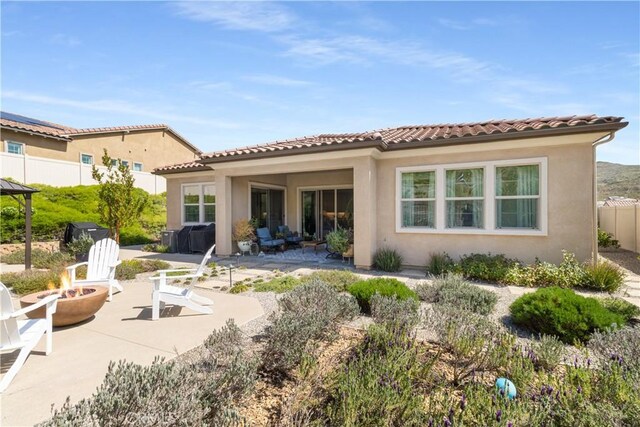 24674 Crestley Dr, Corona, CA 92883 - rear view of property with an outdoor fire pit, a patio, stucco siding, and a tile roof