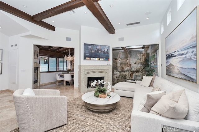 living area with a chandelier, visible vents, a fireplace, and beamed ceiling