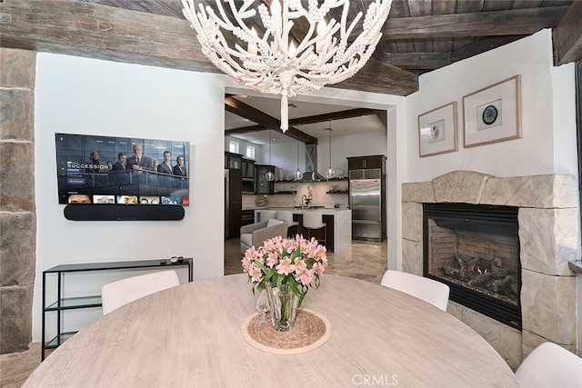 dining area with a tile fireplace, beam ceiling, and a notable chandelier