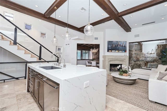 kitchen featuring a sink, visible vents, open floor plan, stainless steel dishwasher, and beam ceiling