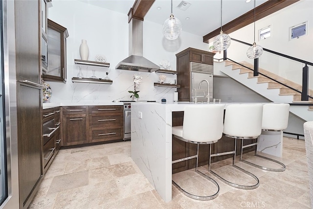 kitchen featuring premium appliances, open shelves, visible vents, dark brown cabinets, and wall chimney exhaust hood