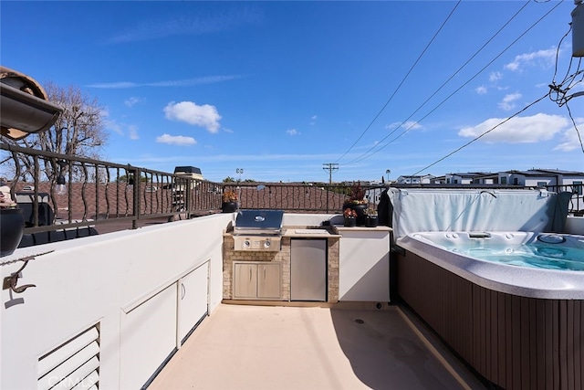 view of patio featuring exterior kitchen, a hot tub, and area for grilling