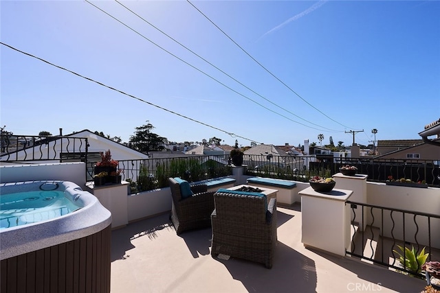 view of patio with a hot tub and fence