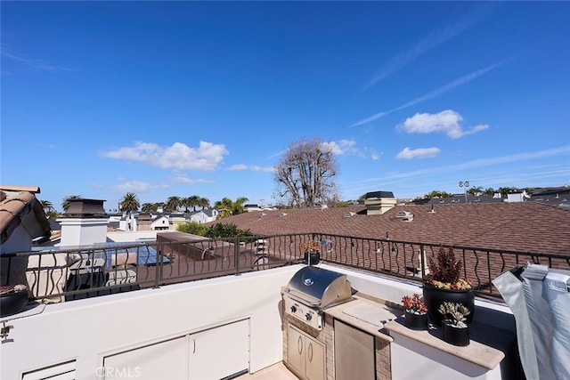 view of patio featuring exterior kitchen, a grill, and a balcony