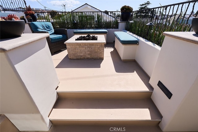 view of patio with an outdoor living space with a fire pit