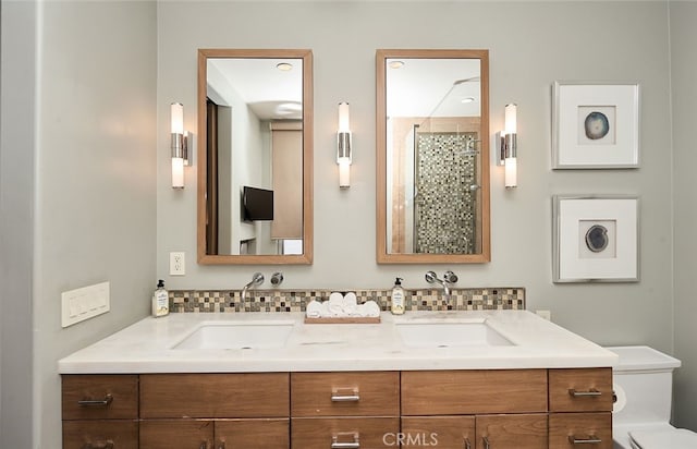 full bath featuring a tile shower, double vanity, a sink, and decorative backsplash