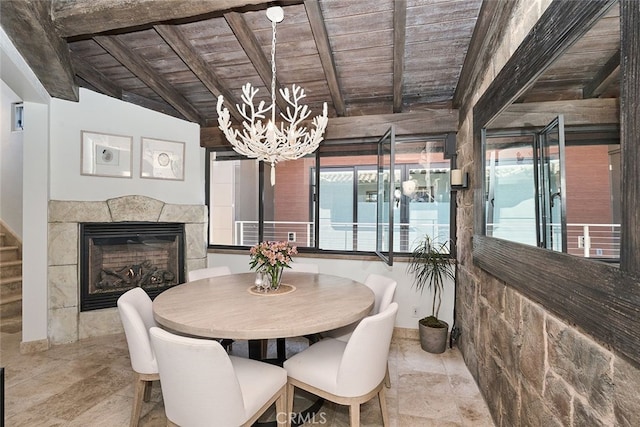 dining space with wooden ceiling, a fireplace, and beamed ceiling