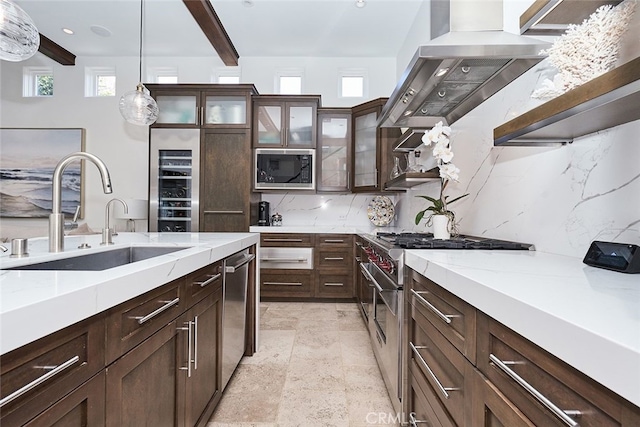 kitchen featuring dark brown cabinetry, decorative backsplash, appliances with stainless steel finishes, range hood, and a sink