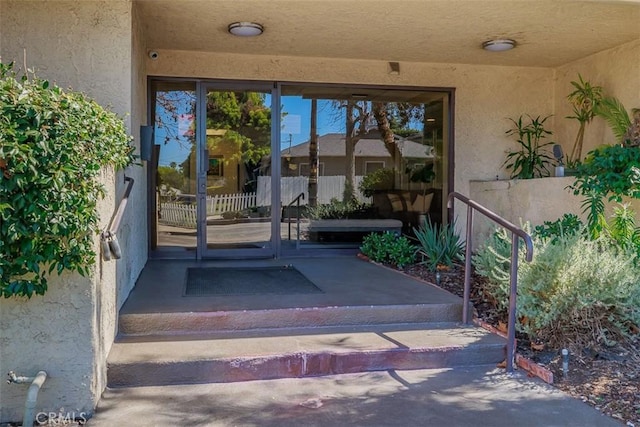 view of exterior entry featuring stucco siding