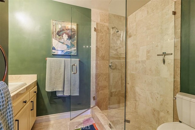 full bath with vanity, toilet, baseboards, and a stall shower