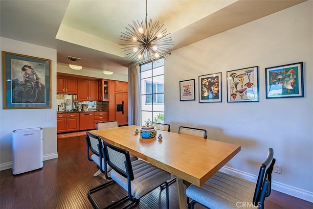 dining room with visible vents, a raised ceiling, an inviting chandelier, baseboards, and dark wood-style flooring