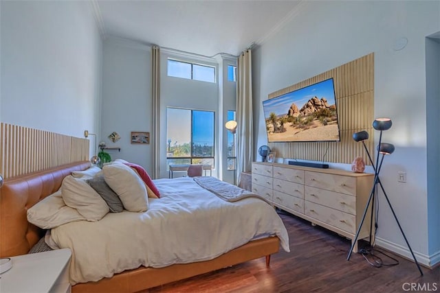 bedroom featuring multiple windows, wood finished floors, baseboards, and ornamental molding