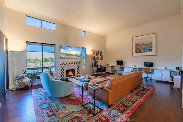 living room featuring a wealth of natural light, a lit fireplace, and hardwood / wood-style flooring