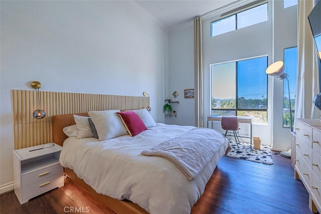 bedroom featuring dark wood-style floors, multiple windows, and crown molding