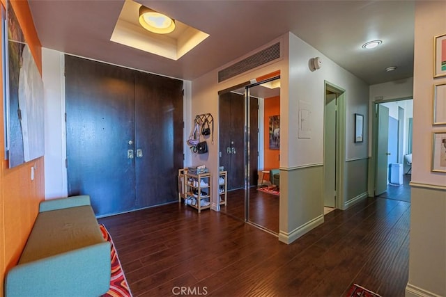 foyer entrance featuring baseboards and wood finished floors