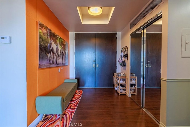 corridor featuring a raised ceiling and wood finished floors