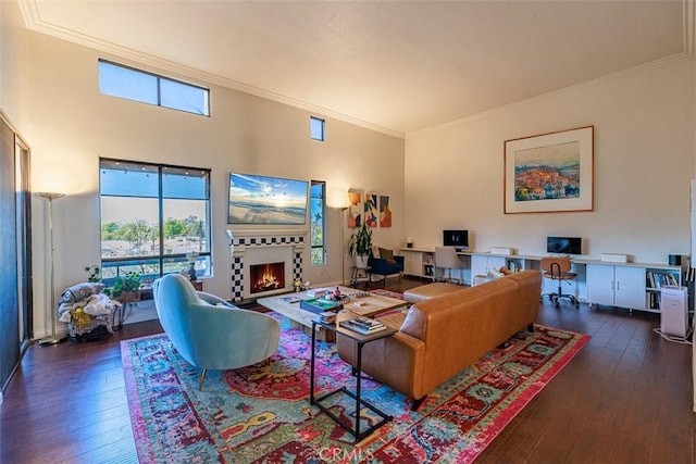 living room with hardwood / wood-style flooring, a wealth of natural light, and a warm lit fireplace