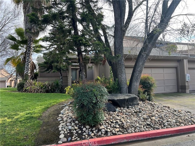 view of front of home with an attached garage, driveway, and a front yard