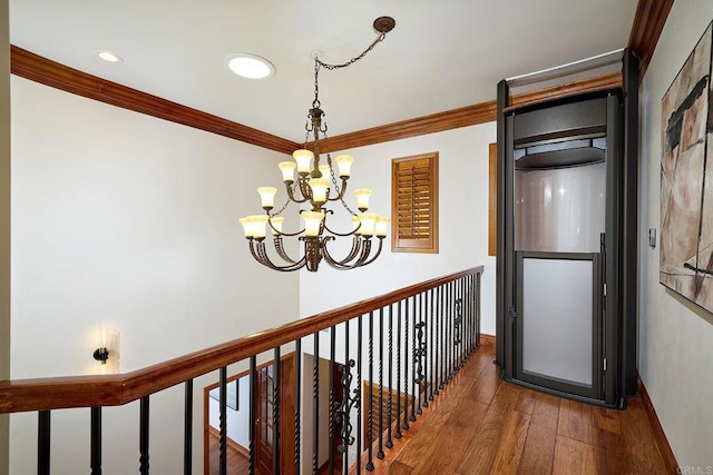 hallway featuring a notable chandelier, ornamental molding, wood finished floors, recessed lighting, and baseboards