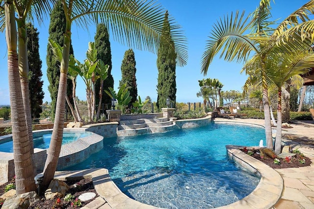 view of pool with a pool with connected hot tub