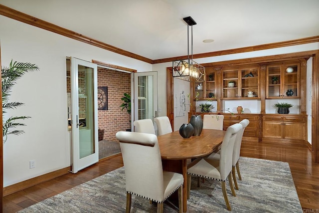 dining area featuring french doors, baseboards, dark wood finished floors, and ornamental molding