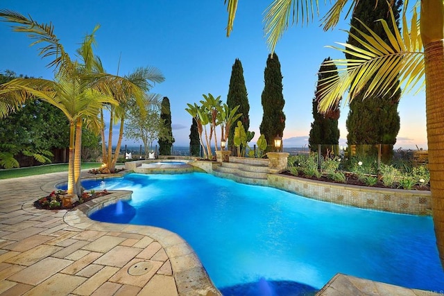 view of pool with a patio area and a pool with connected hot tub