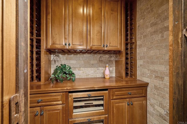 bar with beverage cooler, backsplash, and brick wall