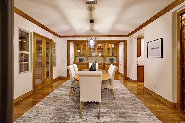 dining area featuring french doors, baseboards, dark wood-style floors, and ornamental molding