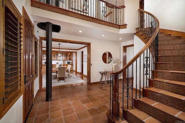 foyer entrance featuring recessed lighting, baseboards, a high ceiling, and stairs