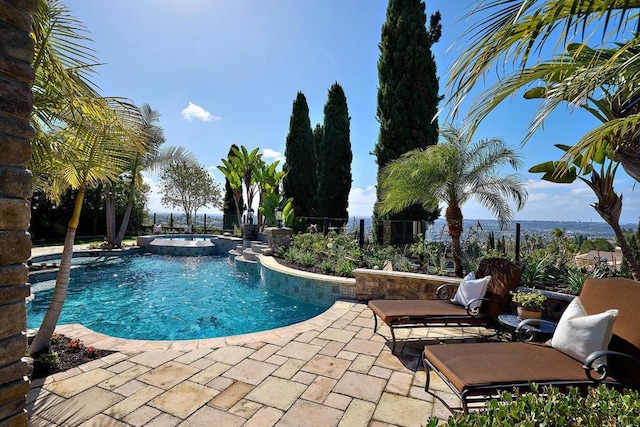 pool featuring a patio area, an in ground hot tub, and fence