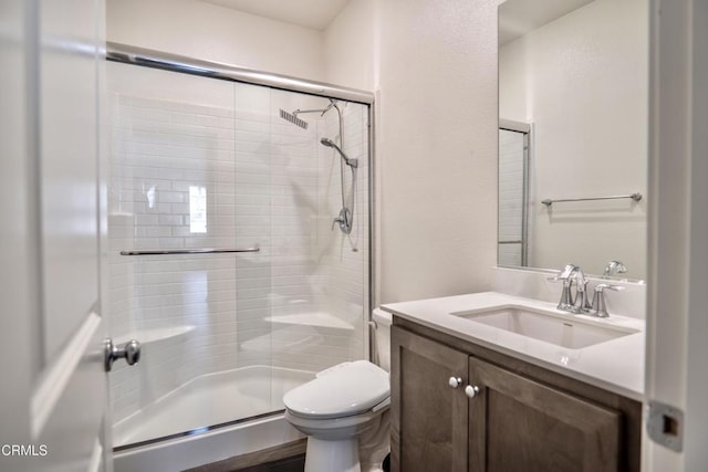 full bath featuring a stall shower, vanity, and toilet