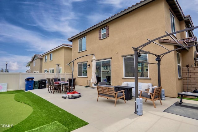 rear view of house featuring a tile roof, a patio, stucco siding, an outdoor hangout area, and fence