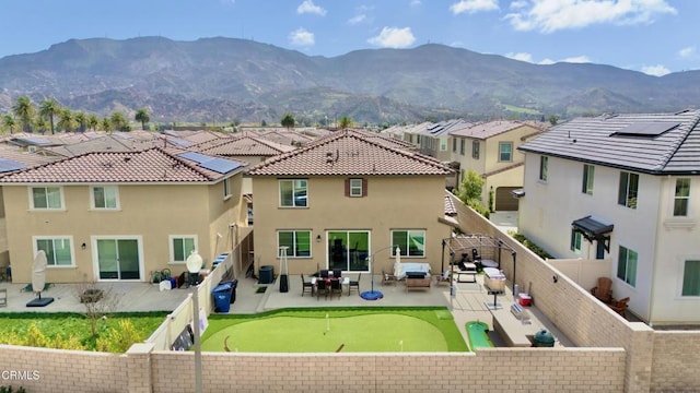 exterior space with a patio, a fenced backyard, a mountain view, and stucco siding