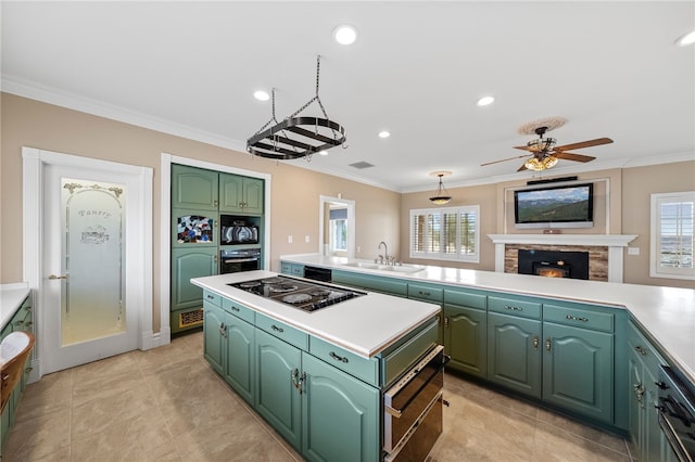 kitchen with black appliances, a healthy amount of sunlight, a sink, and a center island