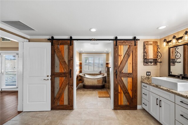 full bathroom with a freestanding bath, vanity, visible vents, and crown molding