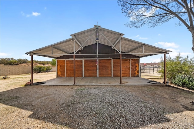 view of outbuilding featuring an outbuilding, a carport, an exterior structure, and driveway