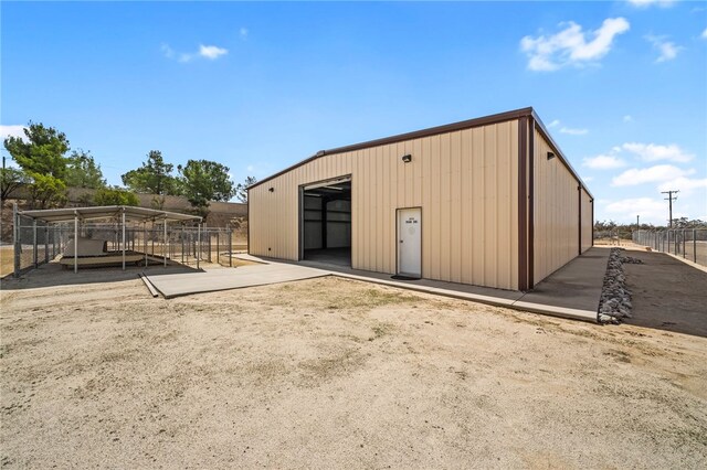 view of outdoor structure featuring an outbuilding and fence