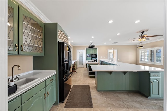 kitchen featuring green cabinetry, ornamental molding, light countertops, black refrigerator with ice dispenser, and a sink