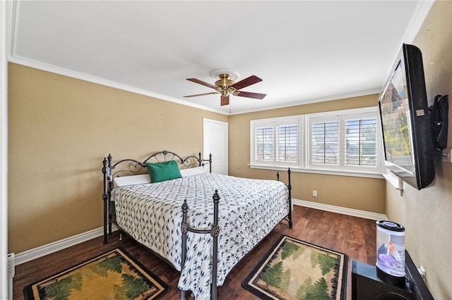 bedroom with a ceiling fan, crown molding, baseboards, and wood finished floors