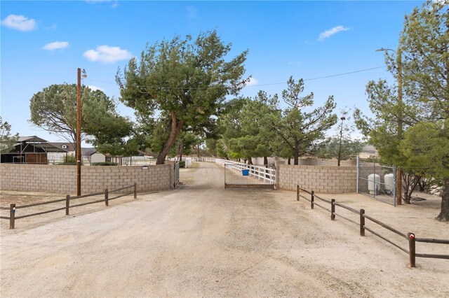 view of street featuring a gate, a gated entry, and dirt driveway